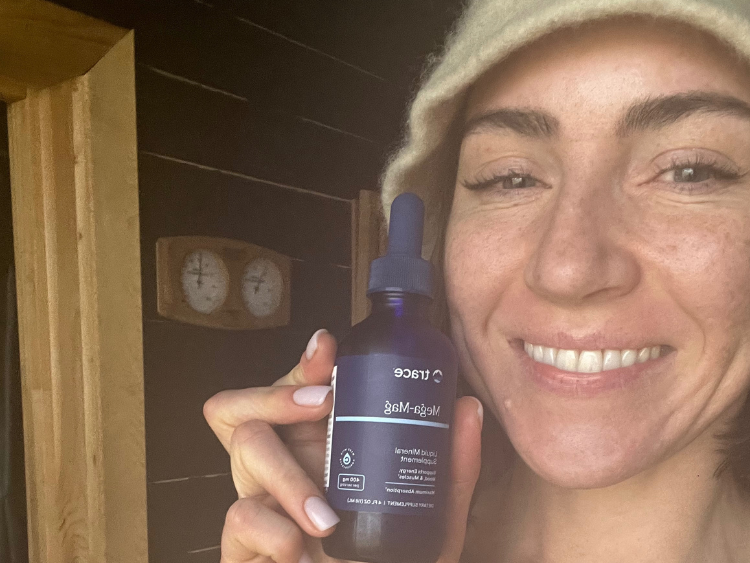 Moteris rankoje laiko Trace Minerals Mega-mag pakuotę ir šypsosi