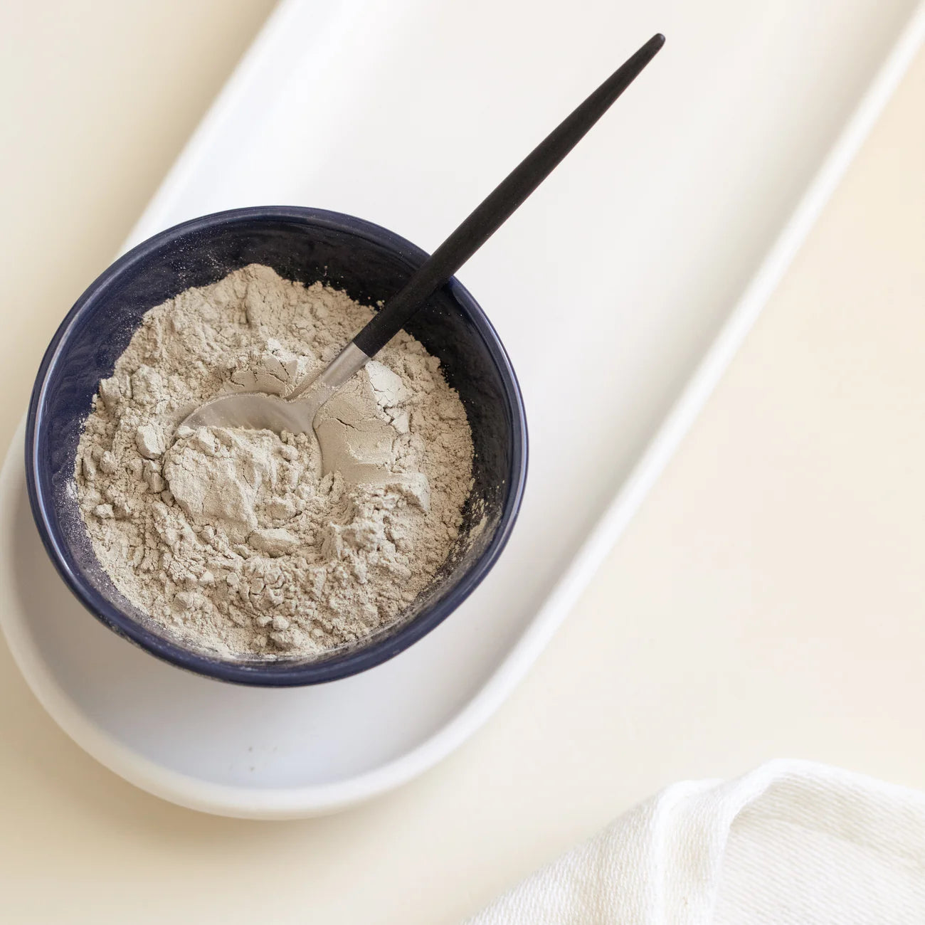 Trace Minerals bentonito molio kaukės milteliai dubenėlyje su šaukšteliu