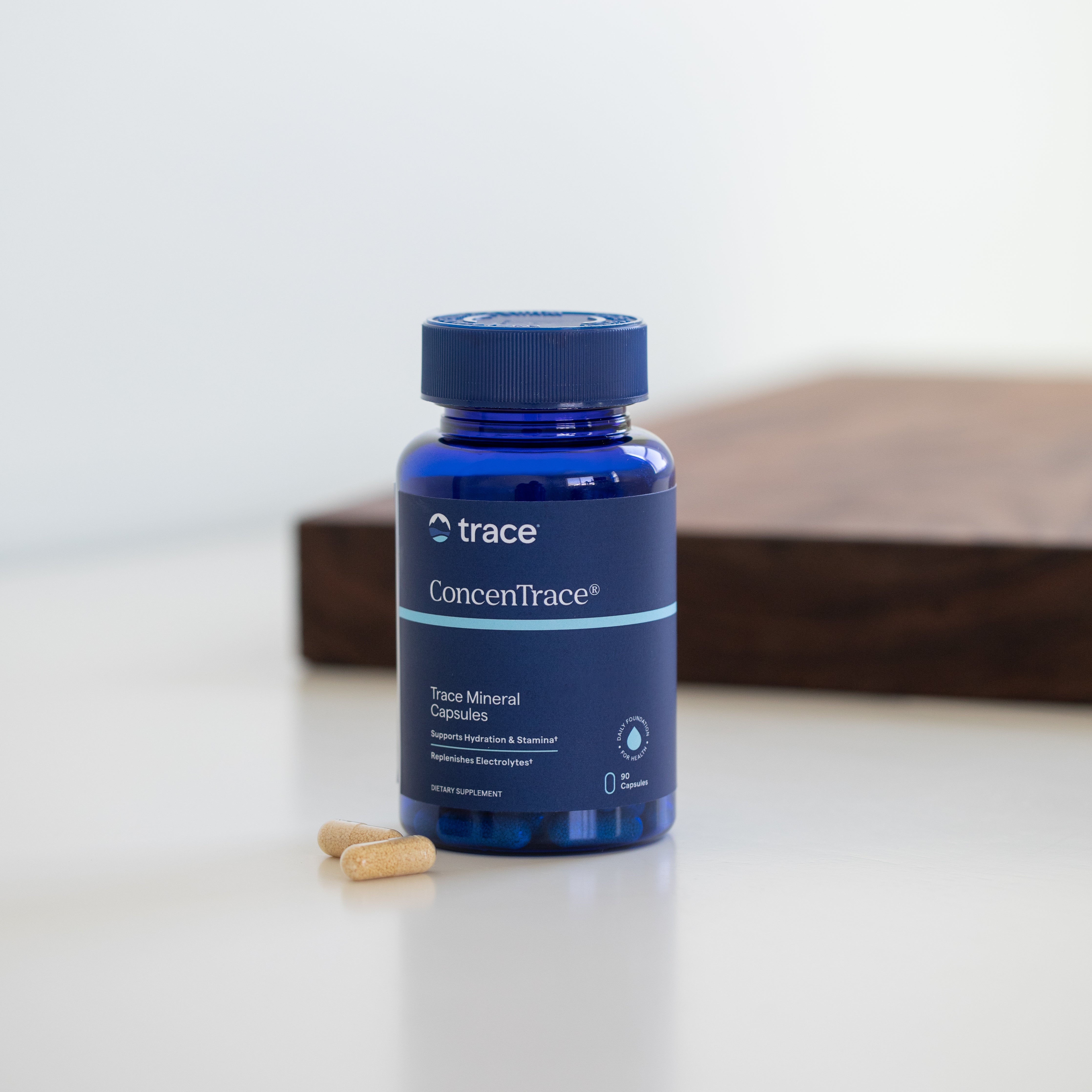 Trace Minerals concentrace joninių mineralų pakuotė ir kapsulės ant stalo