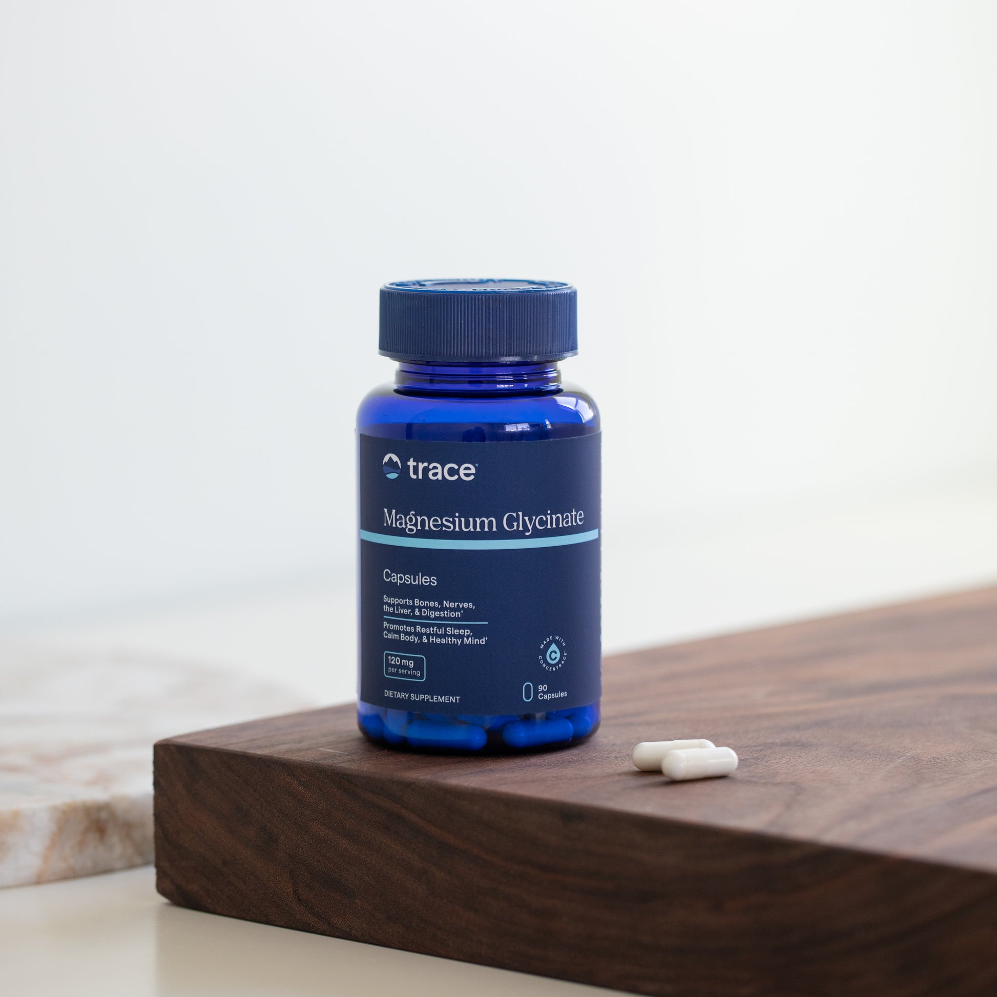 Trace Minerals magnio glicinato 90 kaps. pakuotė ant stalo su kapsulėmis